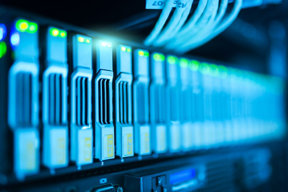A server rack with glowing lights in a modern data center, representing AI compute infrastructure.