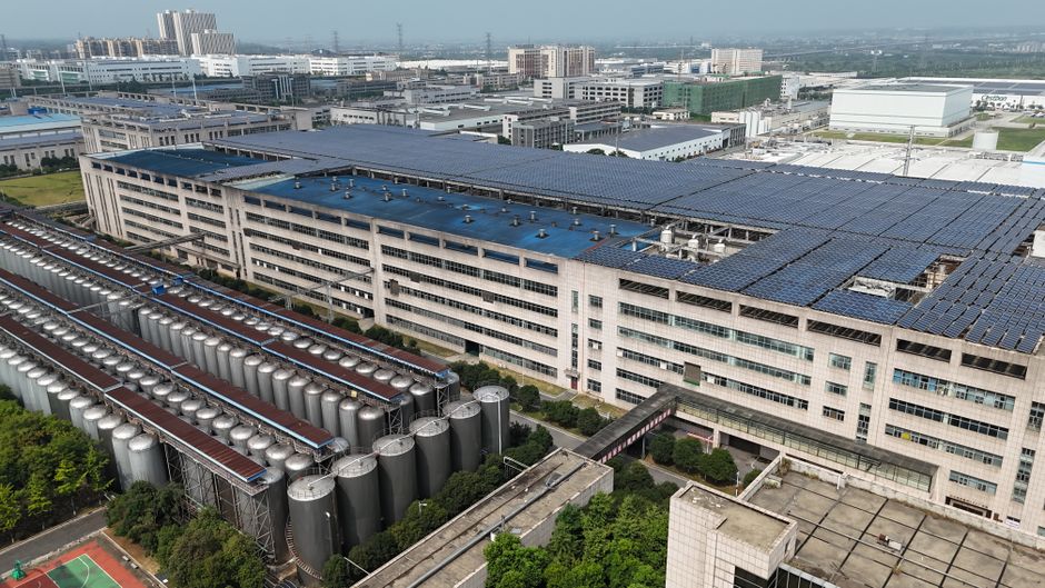 Aerial view of an industrial facility with solar panels and storage tanks.