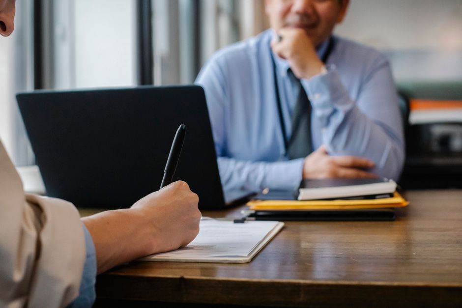 Person filling out a job application form at an office desk