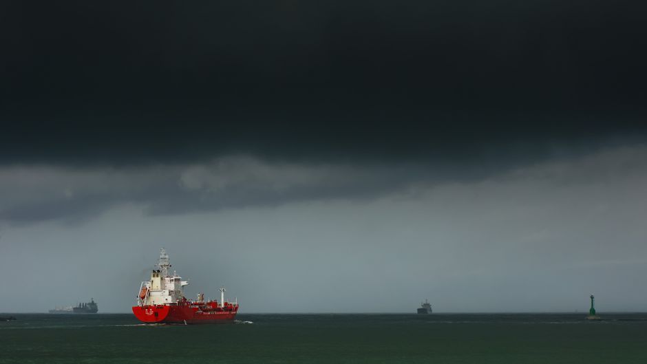 Large cargo vessel navigating under stormy skies on open ocean