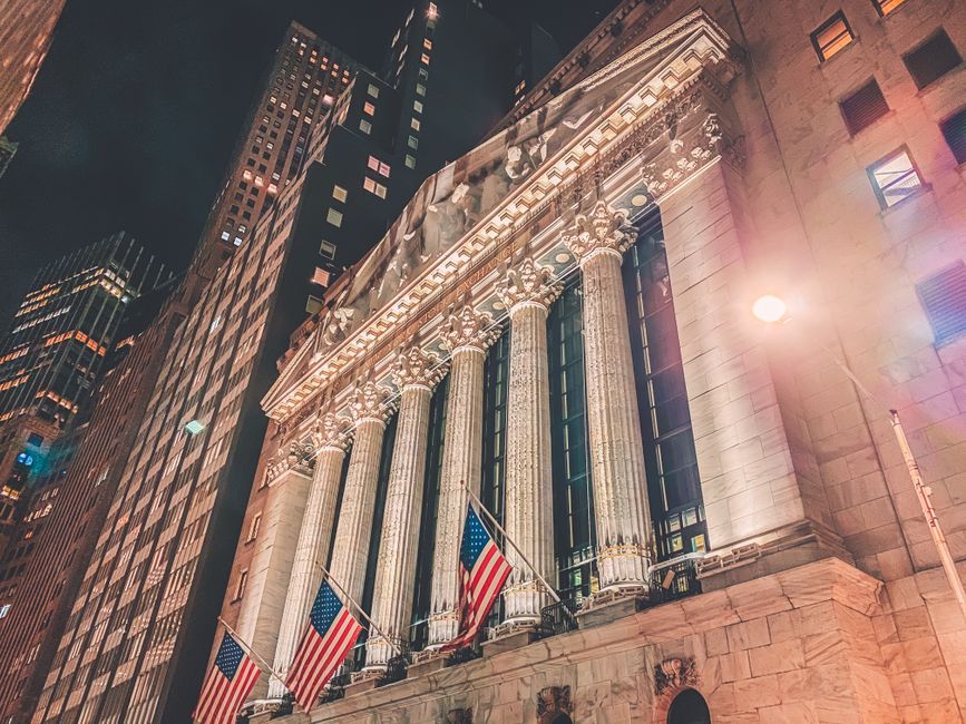 Night view of the New York Stock Exchange building facade illuminated in Manhattan.