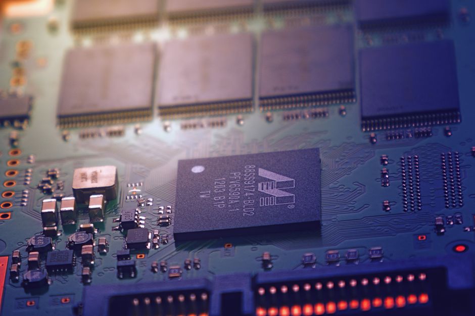 Close-up of a green circuit board with microchips and intricate wiring, representing semiconductor technology