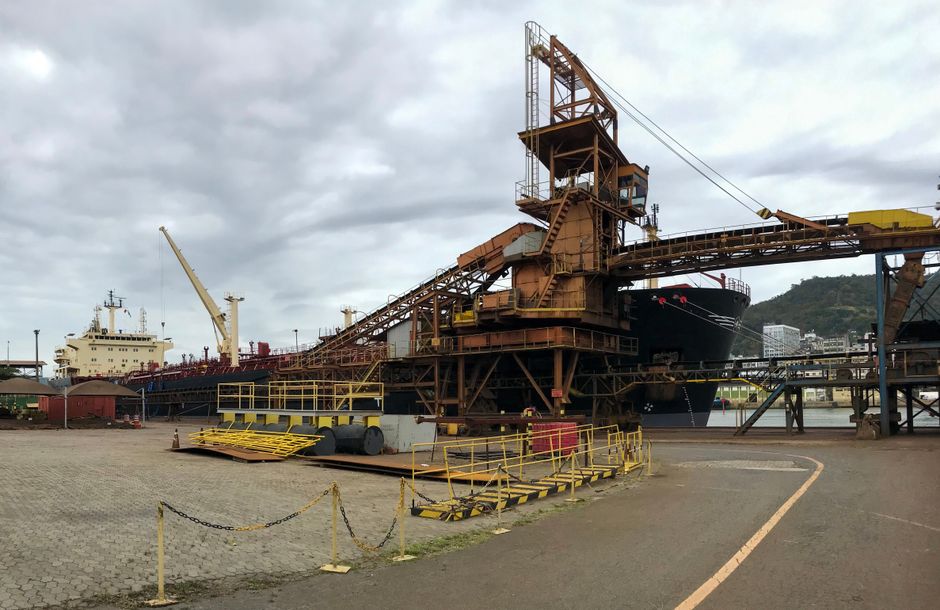 A commercial port with cargo ships and cranes supporting the global fuel supply chain