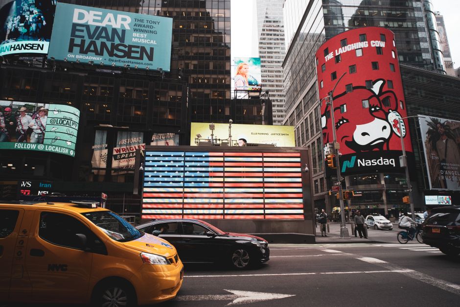 Dynamic view of Times Square with iconic billboards and a yellow taxi in New York City