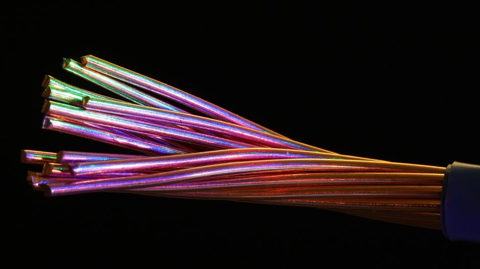 Vibrant multicolor fiber optic cables glowing against a dark background, representing high-speed data infrastructure.