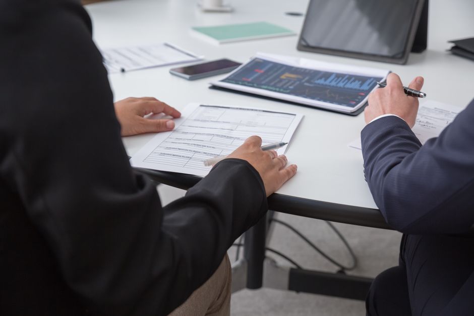 Professionals reviewing capital-markets documents in an office