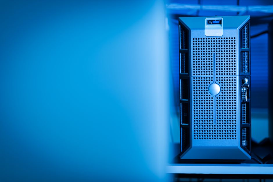 A modern server unit in a blue-lit data center, with rows of computing equipment visible behind it.