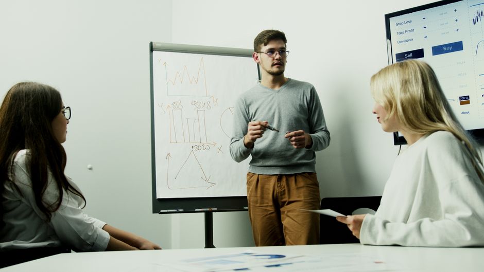 Professionals review financial charts as an IPO roadshow tests investor demand and market depth