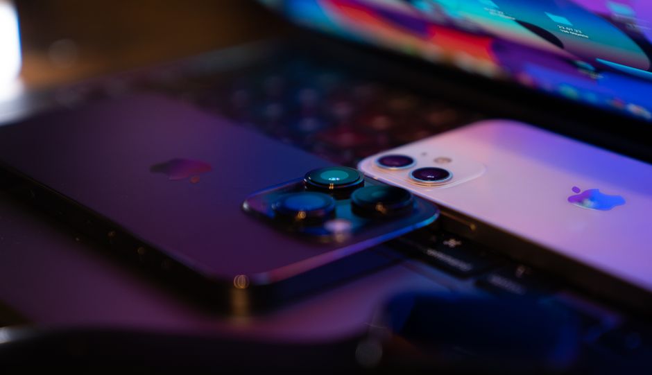 Two modern smartphones placed on a laptop keyboard, highlighting consumer technology