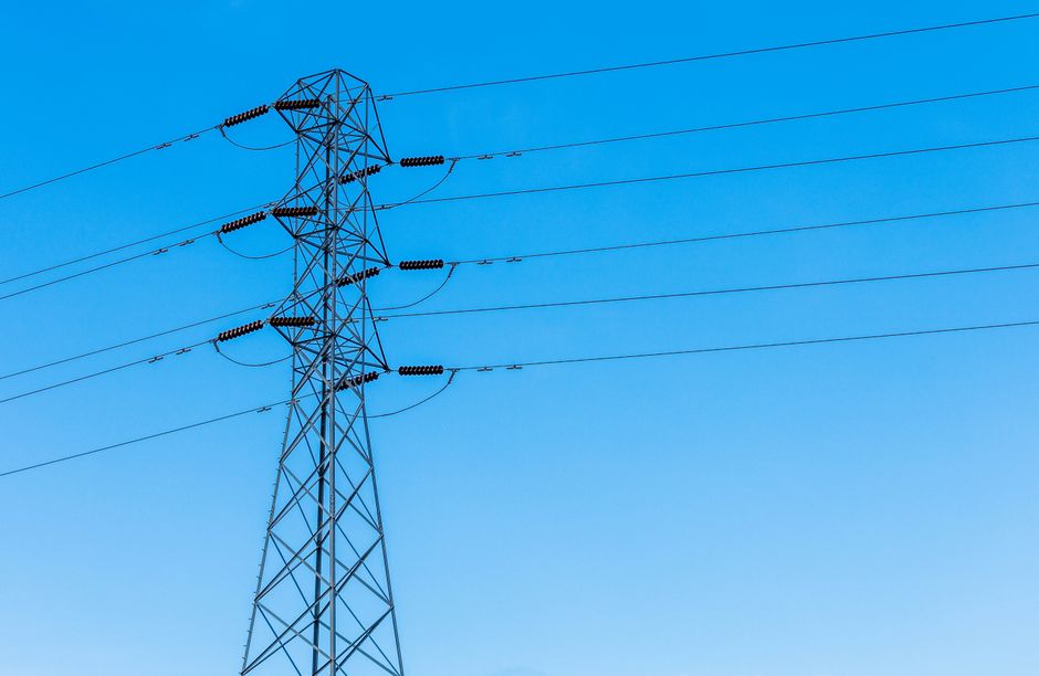 High-voltage transmission lines represent the power and financing burden behind AI data-center expansion.