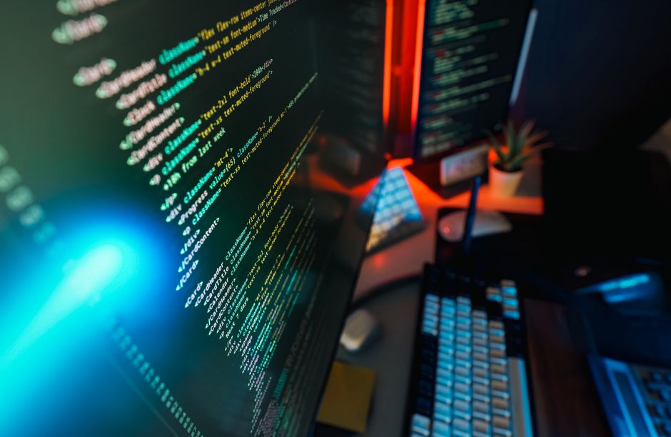A futuristic software development workspace with a glowing monitor showing lines of code, reflecting the observability and data software driving Datadog's re-rate.