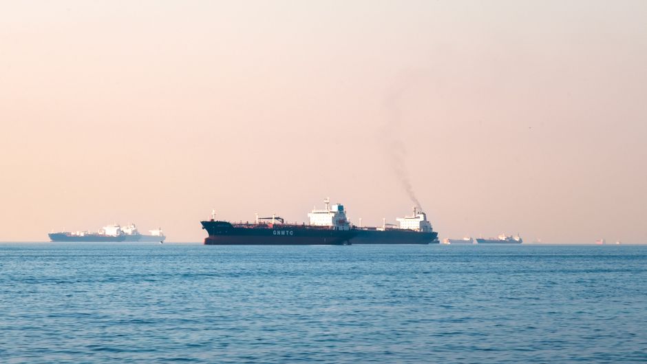 Large industrial tanker ships navigating the open sea under a clear sky, illustrating maritime transportation.