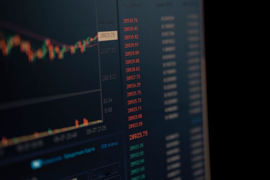 A computer screen displaying real-time financial market data and trading charts on a dark blue background.