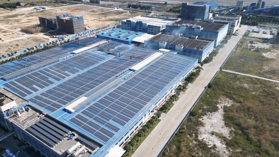 Aerial view of solar panels installed on an industrial building, illustrating the solar energy supply chain affected by new polysilicon tariffs.