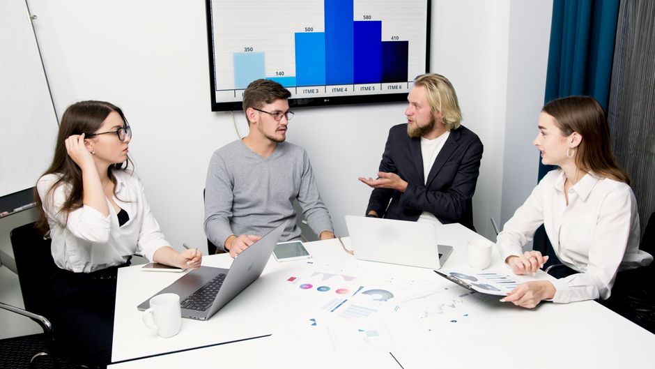 Business professionals discuss enterprise data and demand trends in a research meeting.