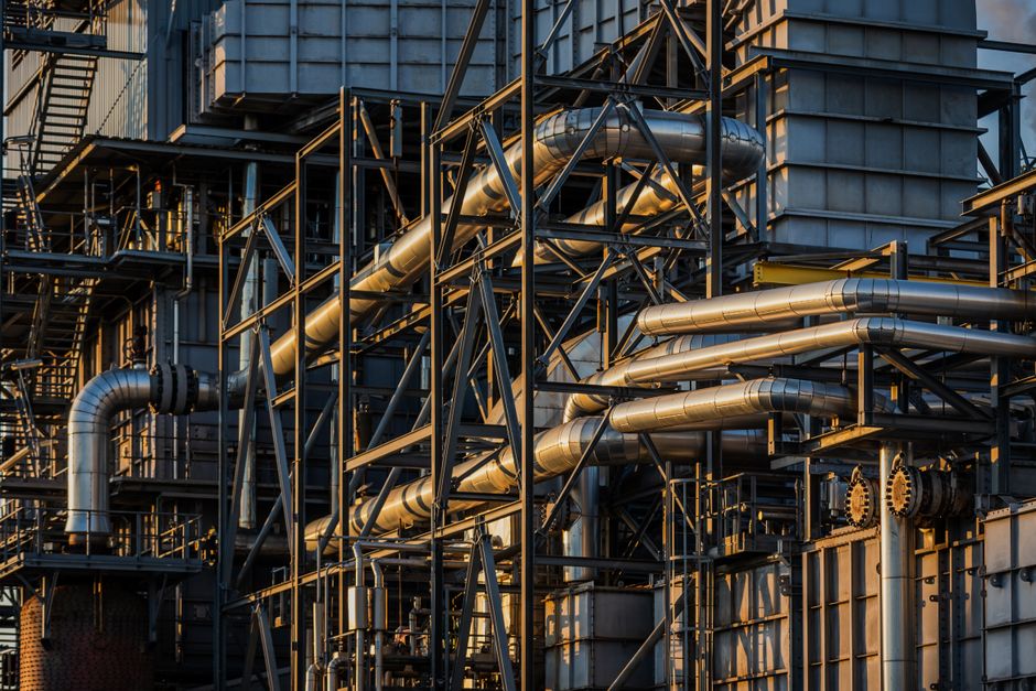 Industrial oil refinery complex with extensive piping and processing structures.