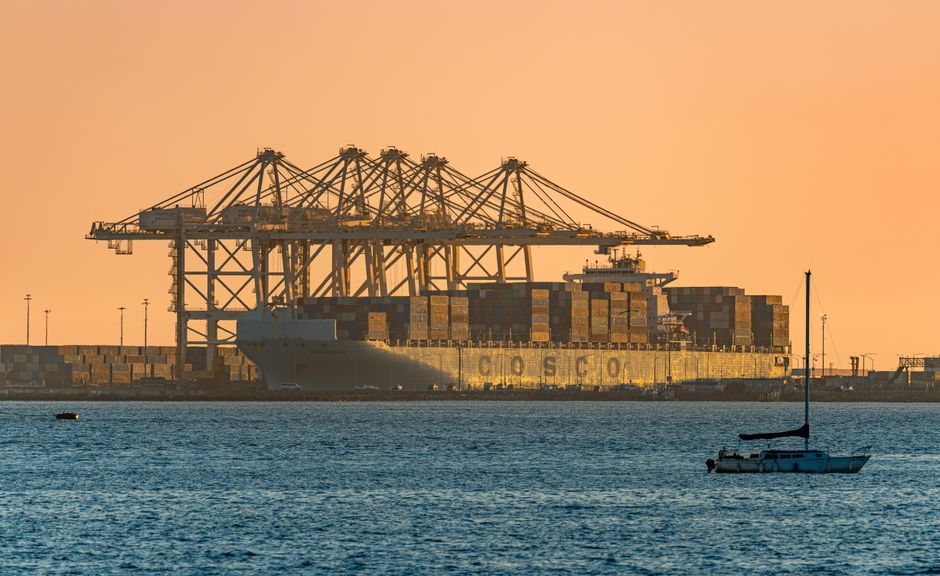 Container ships and port logistics illustrate how Gulf shipping disruptions can transmit into market costs.
