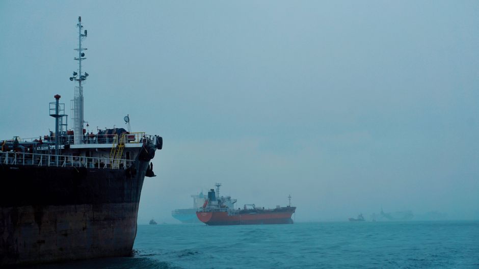 Cargo ships transit hazy waters near a strategically important energy shipping route.