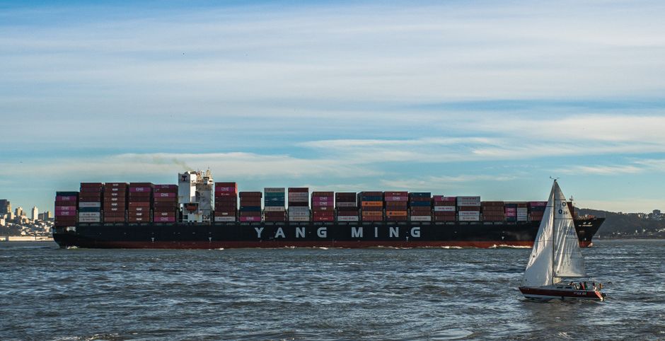 A container ship navigating open water, representing the maritime routes carrying energy and goods through strategic chokepoints.
