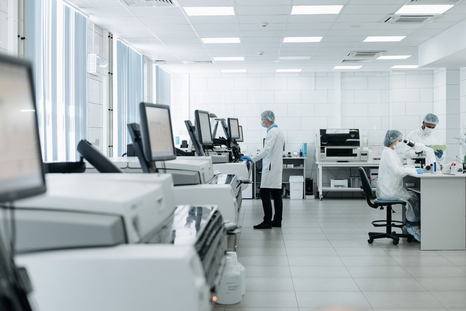 Researchers work in a laboratory as biotech issuers return to public markets