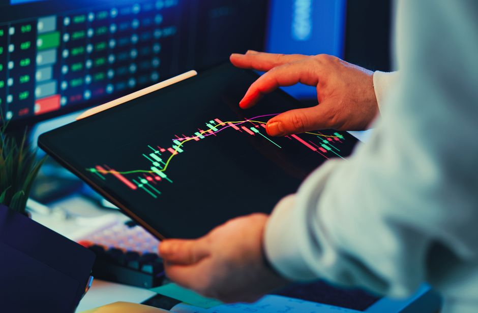 A market participant reviews stock-market data on a tablet.