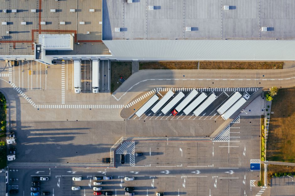 Aerial drone view of a large logistics distribution center with truck loading bays