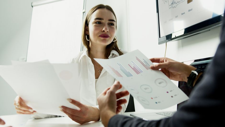 Professionals review charts and reports while evaluating issuance terms, liquidity and earnings quality.