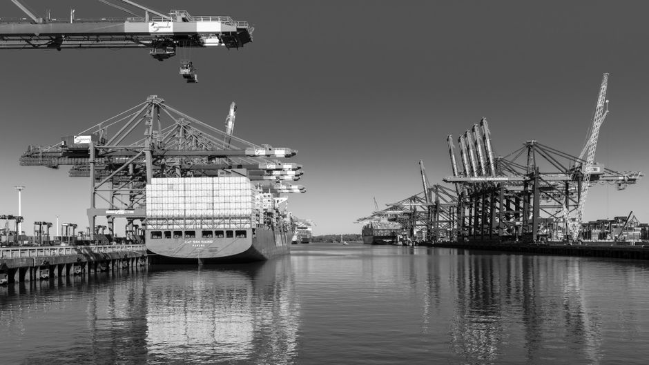 A container port handles global freight as maritime disruption raises trade and energy risks.