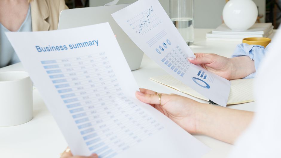 Business professionals reviewing reports related to a public offering.