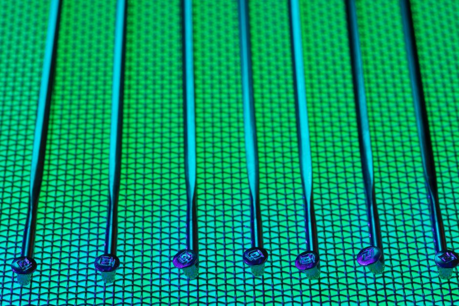 Close-up of a patterned silicon wafer with vibrant green and blue colors, representing semiconductor manufacturing and chip fabrication