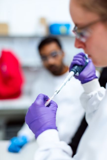 A scientist in a modern laboratory using a pipette for research