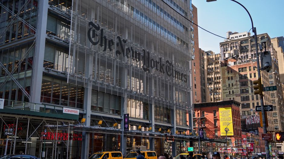 A busy Manhattan street beside a major financial-news building, representing the public-market gateway for new listings.