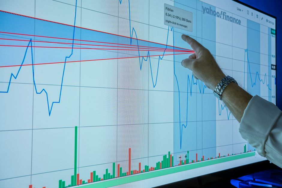 A market analyst reviews financial data on a digital trading screen.