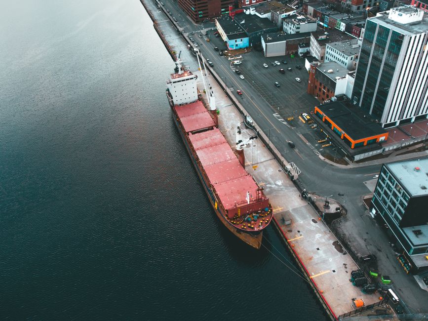 Aerial view of a modern dock with a cargo ship moored in the harbor