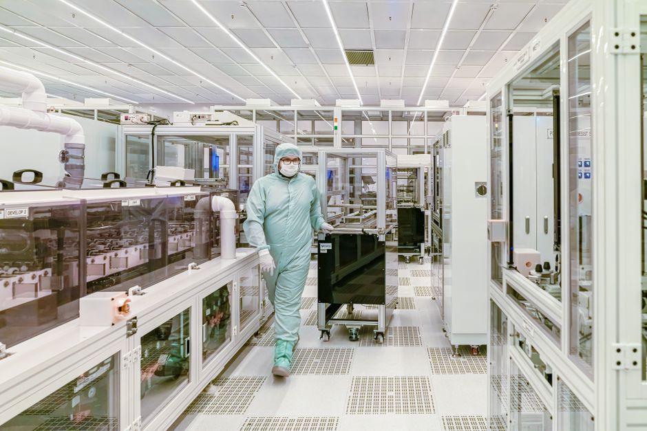 Scientist in protective gear in a semiconductor cleanroom