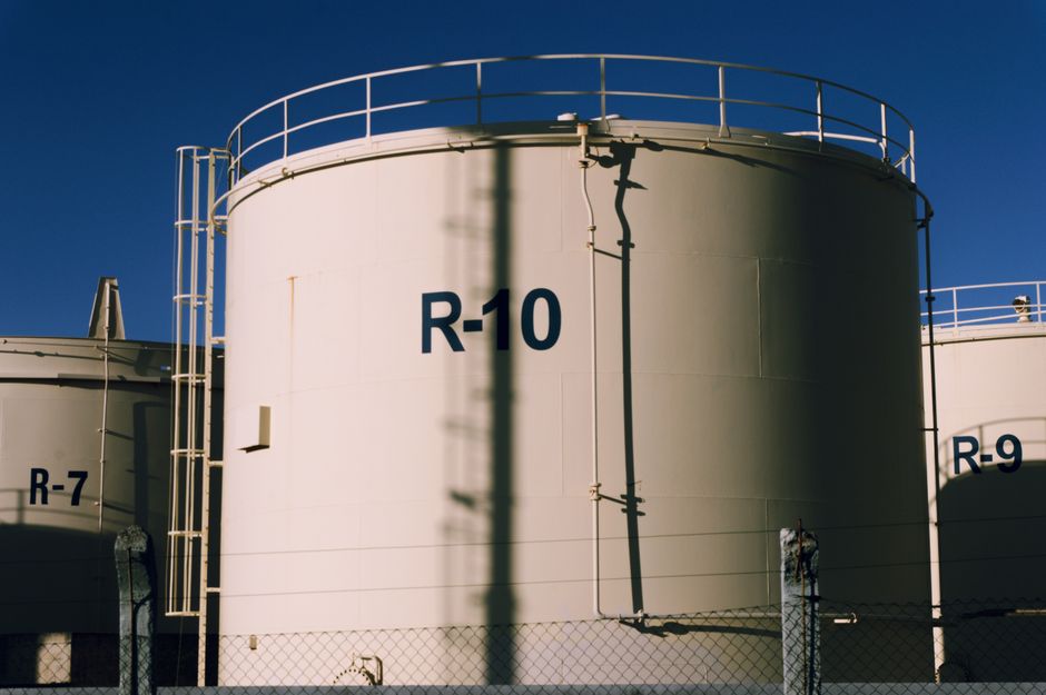 Large industrial storage tanks reflecting the energy infrastructure channel affecting the market.