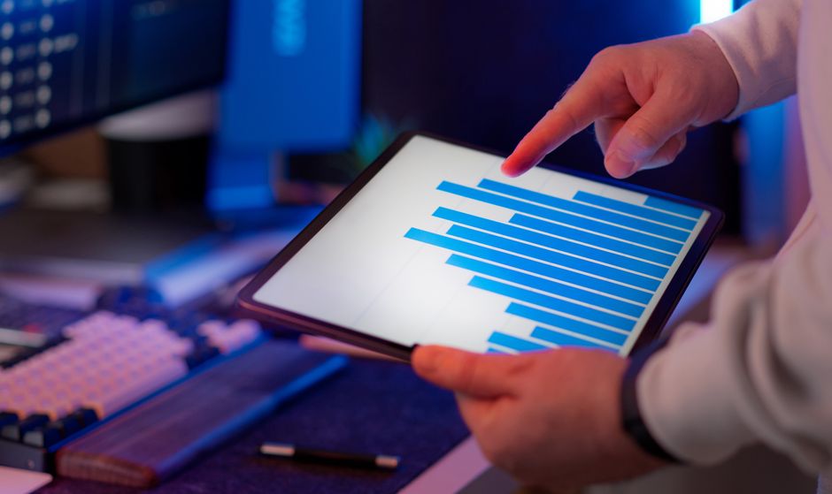 Business professional analyzing a bar chart on a tablet in an office setting