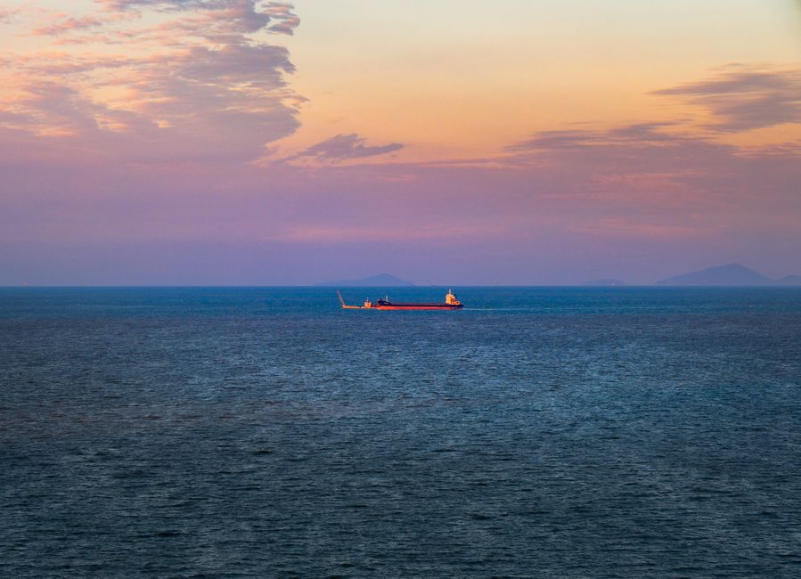 Cargo ship on tranquil ocean at dusk