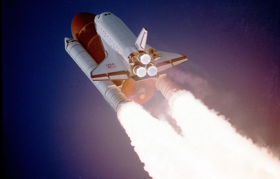 A space shuttle launching into a cloudy sky with bright exhaust plume