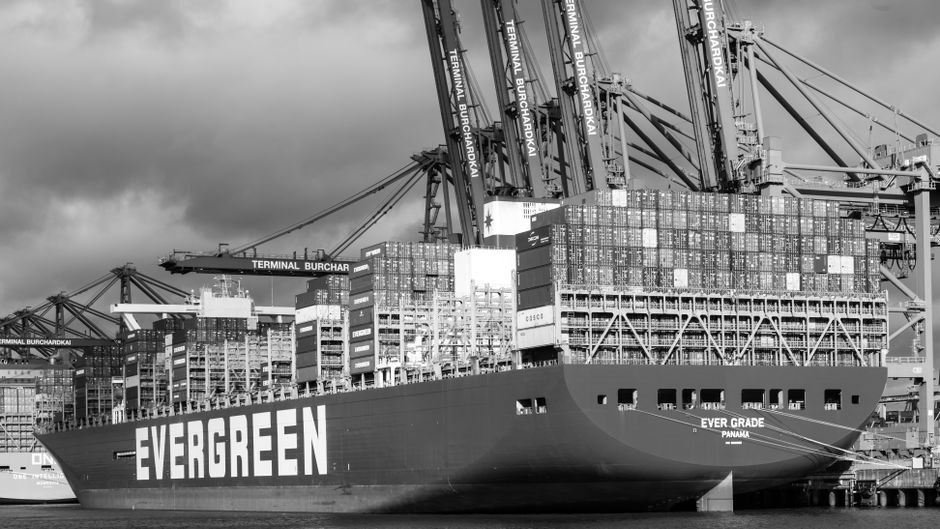 A container ship links the article’s energy and logistics risk to the physical supply chain behind technology infrastructure.