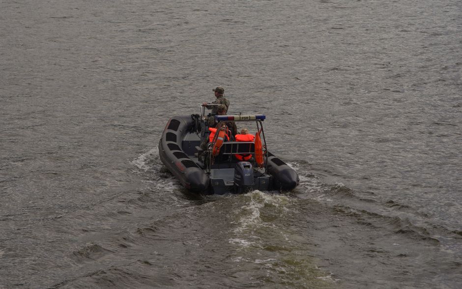 A fast patrol boat navigates open water under overcast skies, illustrating military enforcement at a critical maritime chokepoint.
