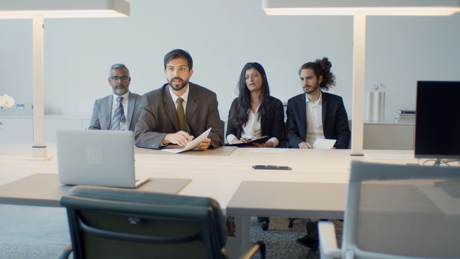 Professionals discuss a public-market offering during a video conference.