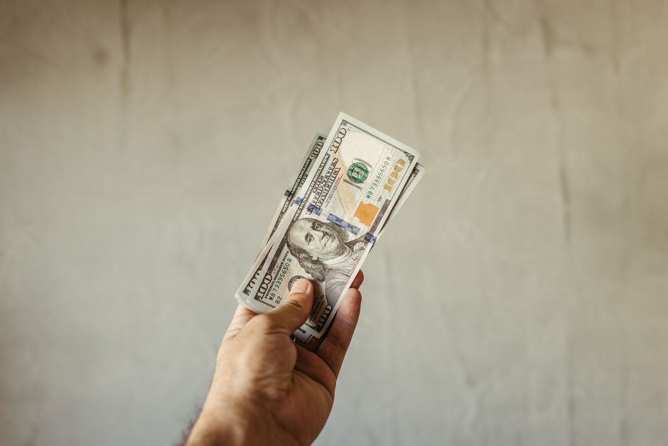 Hand holding US dollar banknotes