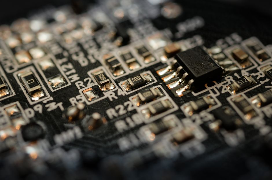 Close-up of a microchip on an electronic circuit board, representing semiconductor demand.