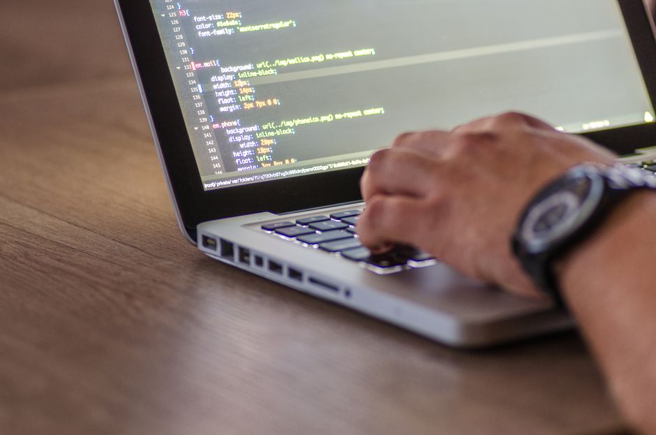 Hands work at a laptop in an enterprise software workspace, representing the cloud-growth side of the thesis.