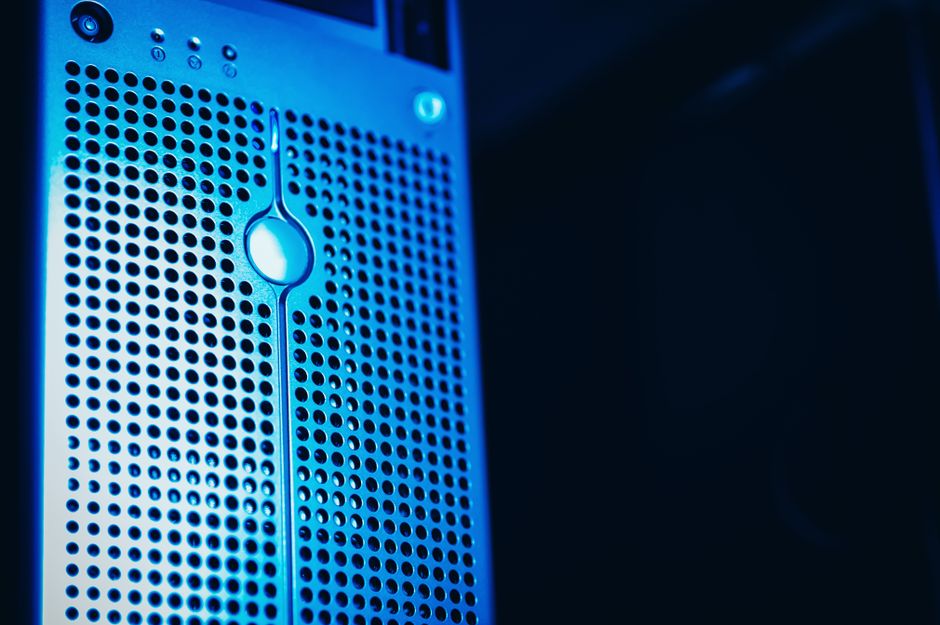 Close-up of a modern server rack with blue lighting in a secure data center, representing the AI infrastructure driving semiconductor demand.