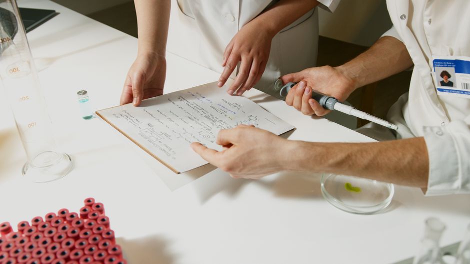 Researchers in a laboratory with documents and scientific equipment, representing biotech research driving new IPO issuance.