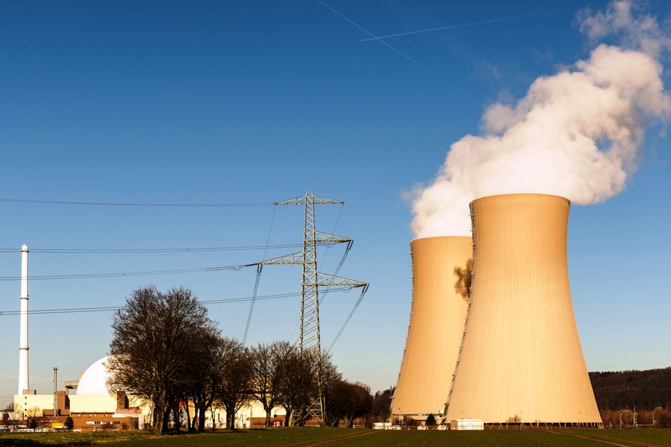A nuclear power plant with cooling towers and electricity pylons, representing energy infrastructure.