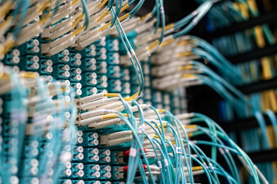 Blue network cables connected to patch panel in data center