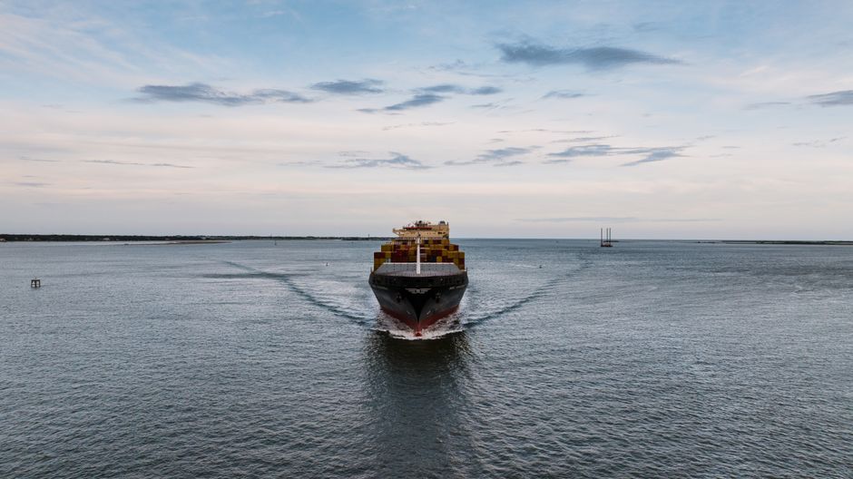 Container ship moving through open water as maritime trade faces geopolitical disruption